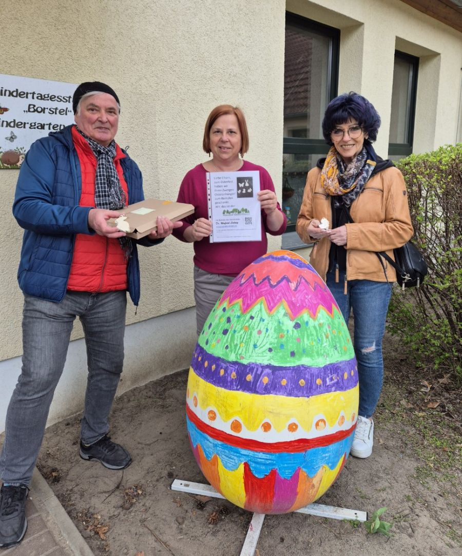 Vereinsmitglieder vor einem Osterei